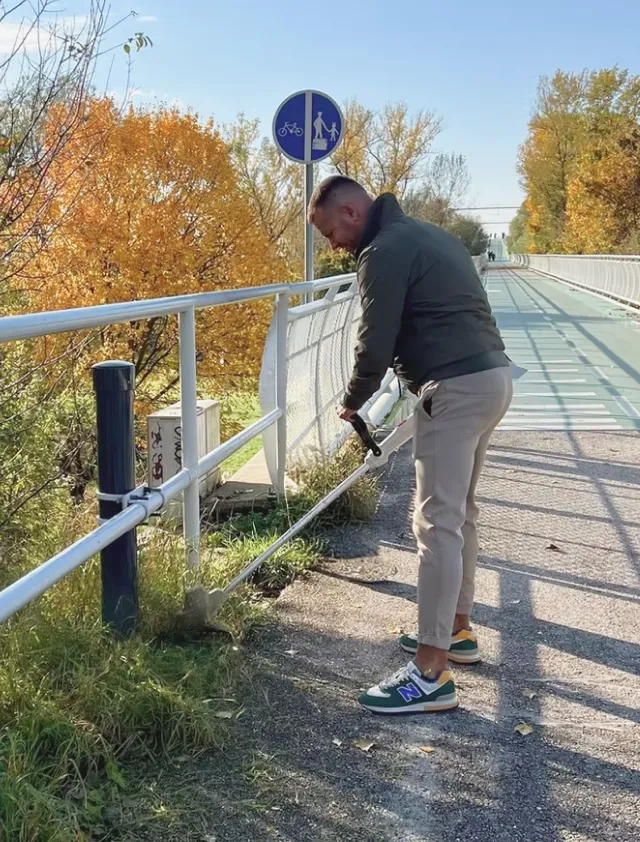 Kosenie prerastenej trávy pri cyklomoste